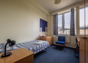 a hotel room with a bed and a desk and a window at LSE Bankside House in London