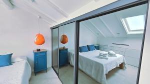 een slaapkamer met een bed en een spiegel bij La Mansarda di Via Niella in Savona