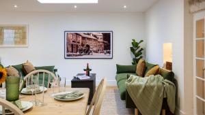 salon z zieloną kanapą i stołem w obiekcie Sage Cottage w mieście Blockley