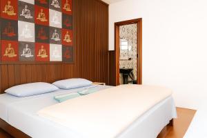 a bedroom with a white bed and a wall at Pousada do Parque in Porto Alegre