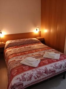 a bedroom with a bed with two towels on it at Casa Preziosa Cielo Alto in Breuil-Cervinia