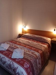 a bedroom with a bed with two towels on it at Casa Preziosa Cielo Alto in Breuil-Cervinia