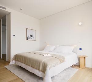 a white bedroom with a large bed with white walls at LENSCAPE Coterie in Porto +148 photos