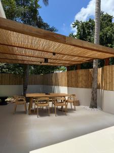 a wooden picnic table and benches under a wooden pergola at Luxury K Villas 04 in Ko Phangan