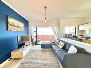 a living room with a couch and a tv at Beach Paradise in Ballito
