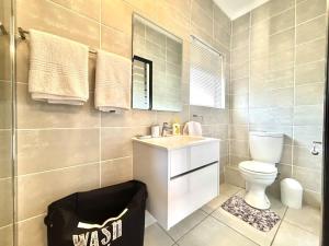 a bathroom with a sink and a toilet and a mirror at Beach Paradise in Ballito +16 photos