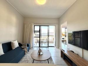 a living room with a blue couch and a tv at Blissnest in Ballito