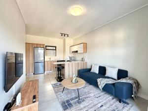 a living room with a blue couch and a table at Blissnest in Ballito +18 photos