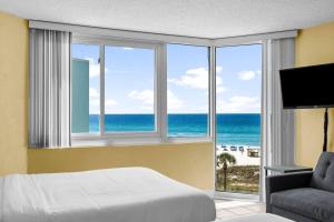 a bedroom with a bed and a view of the ocean at Top Of The Gulf 507 Beach Front Resort Ocean View in Panama City Beach