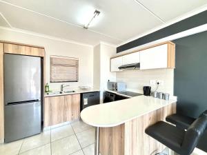 a kitchen with a white counter and a refrigerator at Onyx Oasis in Ballito