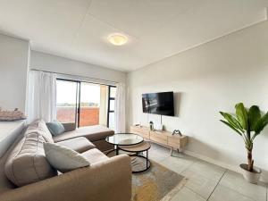 a living room with a couch and a table at Shoreline Sanctuary! in Ballito