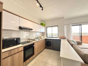 a kitchen with a counter and a couch in it at Shoreline Sanctuary! in Ballito