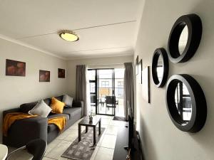 a living room with a couch and mirrors on the wall at The Pearl in Ballito