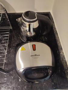 a tea kettle is sitting on top of a counter at Flats do Vale in Petrolina +29 photos