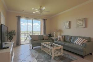 un salon avec un canapé et une table dans l'établissement Second Floor River Strand Condo Overlooking the Golf Course - Sunny Life, à Marsh Island