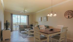 une salle à manger et un salon avec une table et des chaises dans l'établissement Second Floor River Strand Condo Overlooking the Golf Course - Sunny Life, à Marsh Island