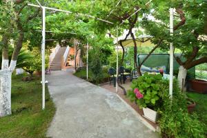 una pasarela en un jardín con mesa y sillas en Apartment Enjoy You, en Split