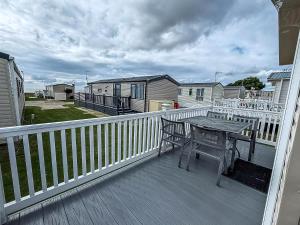 a deck with a table and a bench on it at Caravan With Large Decking At Coopers Beach Holiday Park Ref 49012Sv in East Mersea