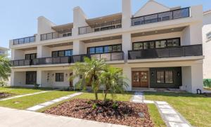 a building with a palm tree in front of it at Be A Nomad - Oceanview Luxe, 5BR Retreat in Jacksonville Beach