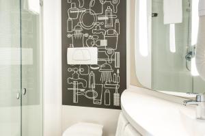 baño con un diseño en blanco y negro en la pared en ibis Paris Saint-Denis Stade Sud, en Saint-Denis