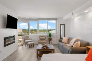 a living room with a couch and a fireplace at Top Of The Gulf 622 - Beach Front Condo Resort in Panama City Beach
