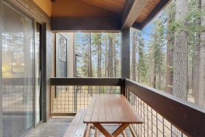 un banco de madera en el balcón de una casa en Aspen Grove Getaway, en Kingswood Estates