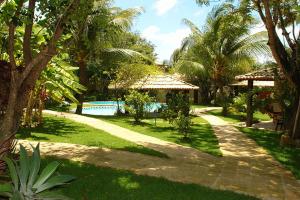 a garden with a swimming pool and a resort at Pousada das Canoas in Pipa