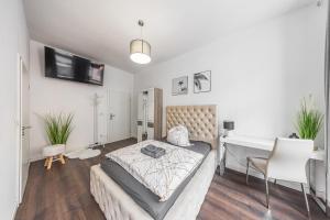 a bedroom with a bed and a desk in it at Moderne Single Apartments Hauptbahnhof in Halle an der Saale +9 photos