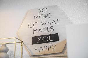a sign that says do more of what makes you happy at Moderne Single Apartments Hauptbahnhof in Halle an der Saale