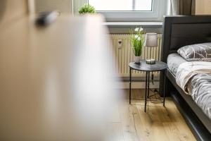 a bedroom with a bed and a table with a lamp at Moderne Single Apartments Hauptbahnhof in Halle an der Saale