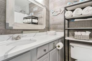 a white bathroom with a sink and a mirror at Beach Front Ocean View Condo - Top Of The Gulf 804 in Panama City Beach +11 photos