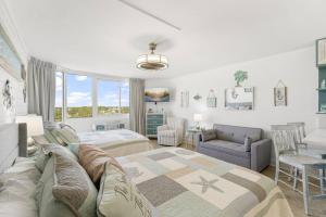 a bedroom with a bed and a couch at Beach Front Ocean View Condo - Top Of The Gulf 804 in Panama City Beach