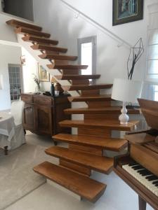 a wooden staircase in a living room with a piano at Villa élégante à Céreste avec piscine privée et jacuzzi in Céreste