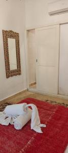 マラケシュにあるRiad Siena IIの赤い絨毯と鏡とドアのある部屋