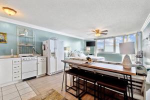巴拿马城海滩Top Of The Gulf 803 - Luxury Beach View Condo的配有冰箱和桌椅的厨房