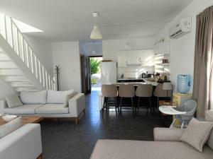 a living room with a couch and a kitchen at Sunny, big pool, garden-roof terrace view Cornervilla on area Kyrenia-Bahceli North-Cyprus in Bahçeli
