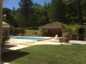 a backyard with a swimming pool and a house at Villa élégante à Céreste avec piscine privée et jacuzzi in Céreste