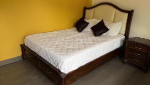 a bed with white sheets and black pillows in a room at hacienda hotel texas in Durania