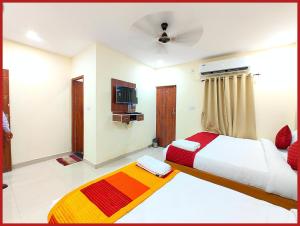 a bedroom with two beds and a television in it at Hotel New Kashi - Grand Near Vishwanath Temple - Fully Air Conditioned Rooms - #Restaurant #Wi-fi #Lift # Parking Facilities - A Top Rated Hotel in Varanasi