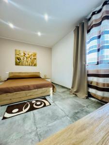 a bedroom with a bed and a rug on the floor at Casa Gavedi in Avola