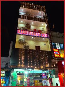 a tall building with a neon sign on it at Hotel New Kashi - Grand Near Vishwanath Temple - Fully Air Conditioned Rooms - #Restaurant #Wi-fi #Lift # Parking Facilities - A Top Rated Hotel in Varanasi