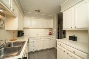 a kitchen with white cabinets and a sink at Woodland Springs in Gladewater +18 photos