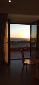 a chair in a room with a view of the ocean at Mani Sol Apartments in Kotrónion