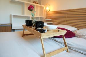 a wooden table with a flower on top of a bed at Charming apartment with private garden in Colomiers