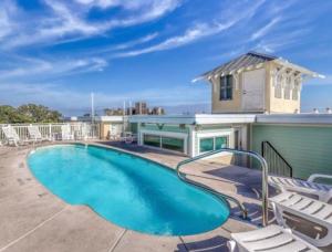una piscina con sillas y una casa en Captains Watch by Tybee Vacation Rentals, en Tybee Island