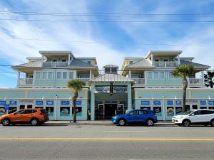 Un gran edificio con coches aparcados delante. en Captains Watch by Tybee Vacation Rentals, en Tybee Island