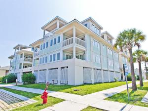un gran edificio de apartamentos con una boca de incendios roja delante de él en Captains Watch by Tybee Vacation Rentals, en Tybee Island