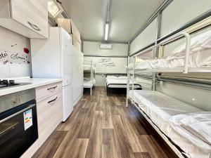 a room with two bunk beds and a kitchen at Area Sosta Camper Policoro in Policoro