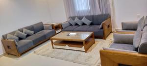 a living room with couches and a coffee table at رفا للشقق المخدومة in Quai