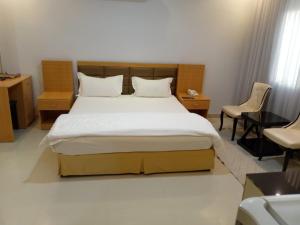 a bedroom with a large bed and chairs in it at رفا للشقق المخدومة in Quai